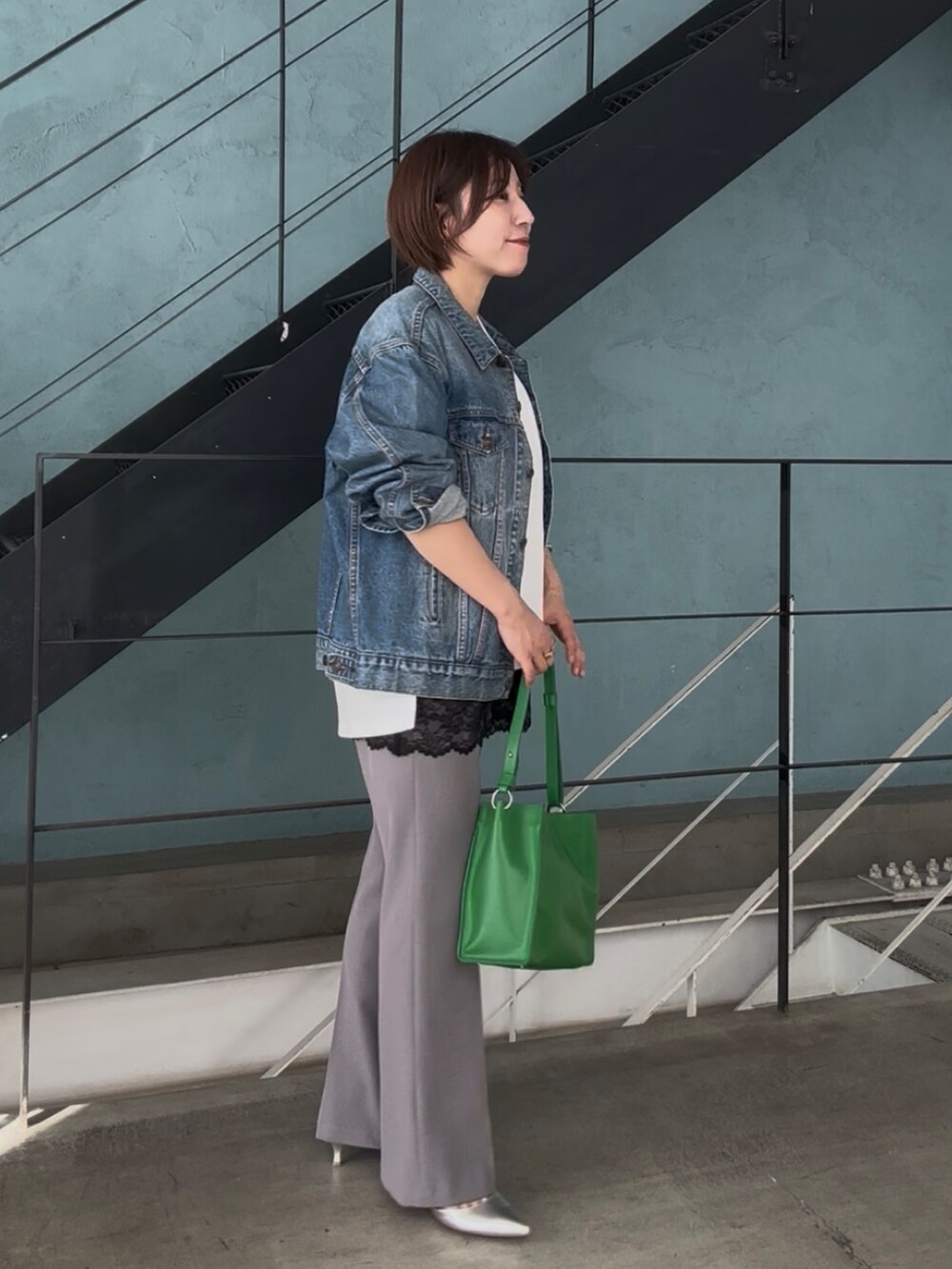 ブルー系のデニムジャケット、ホワイト系のスウェット、ブラック系のキャミソールを着用したレディースの冬コーディネートの4枚目の写真