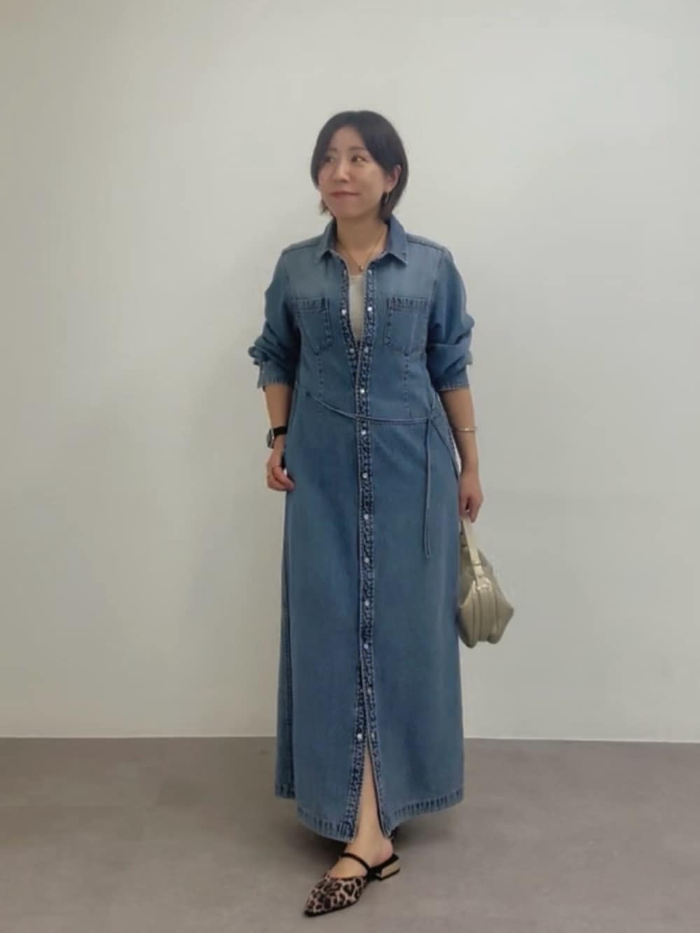 ブルー系のワンピース、ゴールド系のショルダーバッグ、ベージュ系のその他シューズを着用したレディースの春コーディネートの2枚目の写真