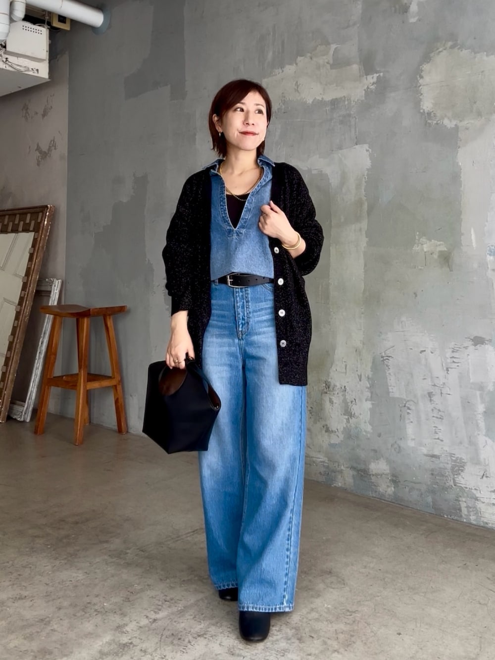 ブラック系のハンドバッグ、ブルー系のデニムパンツ、ブルー系のシャツ/ブラウスを着用したレディースの秋コーディネートの6枚目の写真