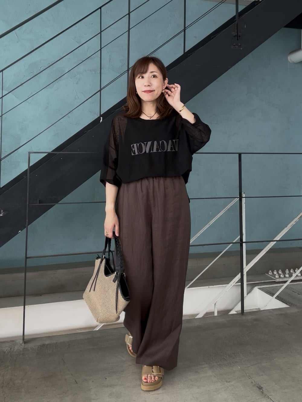 ブラック系のニット/セーター、ブラック系のその他パンツ、ベージュ系のサンダルを着用したレディースの春コーディネートの2枚目の写真