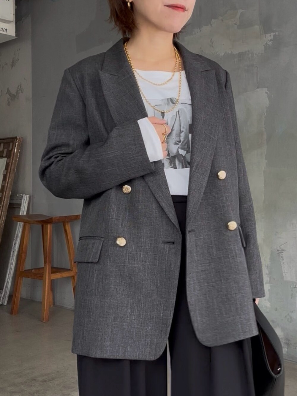 ブラック系のスラックス、ホワイト系のTシャツ/カットソー、グレー系のテーラードジャケットを着用したレディースの秋コーディネートの6枚目の写真