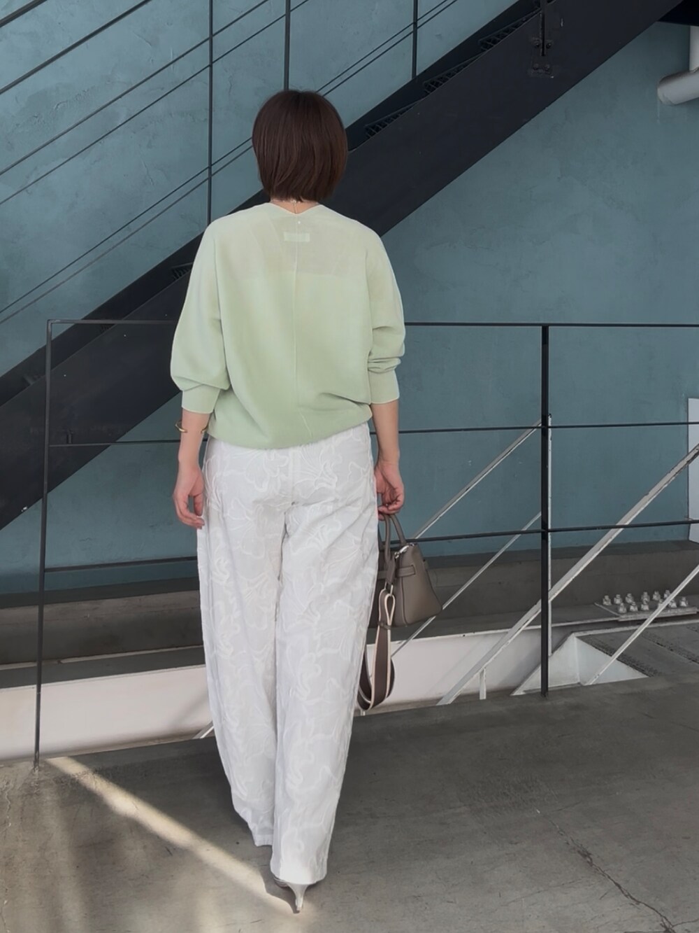 グリーン系のニット/セーター、グレー系のトートバッグ、シルバー系のその他シューズを着用したレディースの冬コーディネートの5枚目の写真