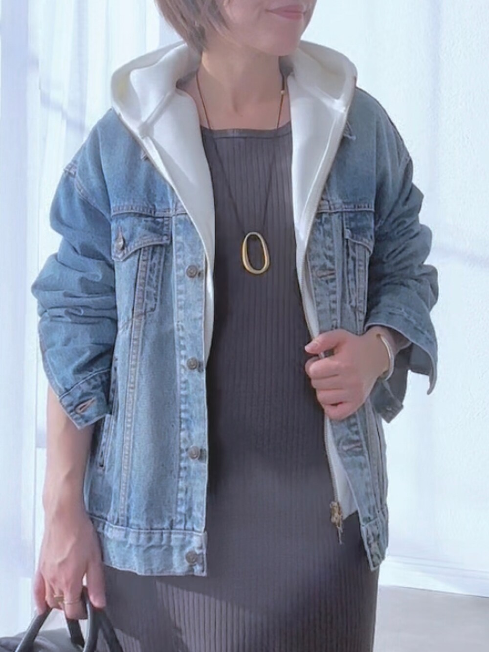 ブルー系のデニムジャケット、グレー系のワンピース、ブラウン系のパンプスを着用したレディースの冬コーディネートの6枚目の写真