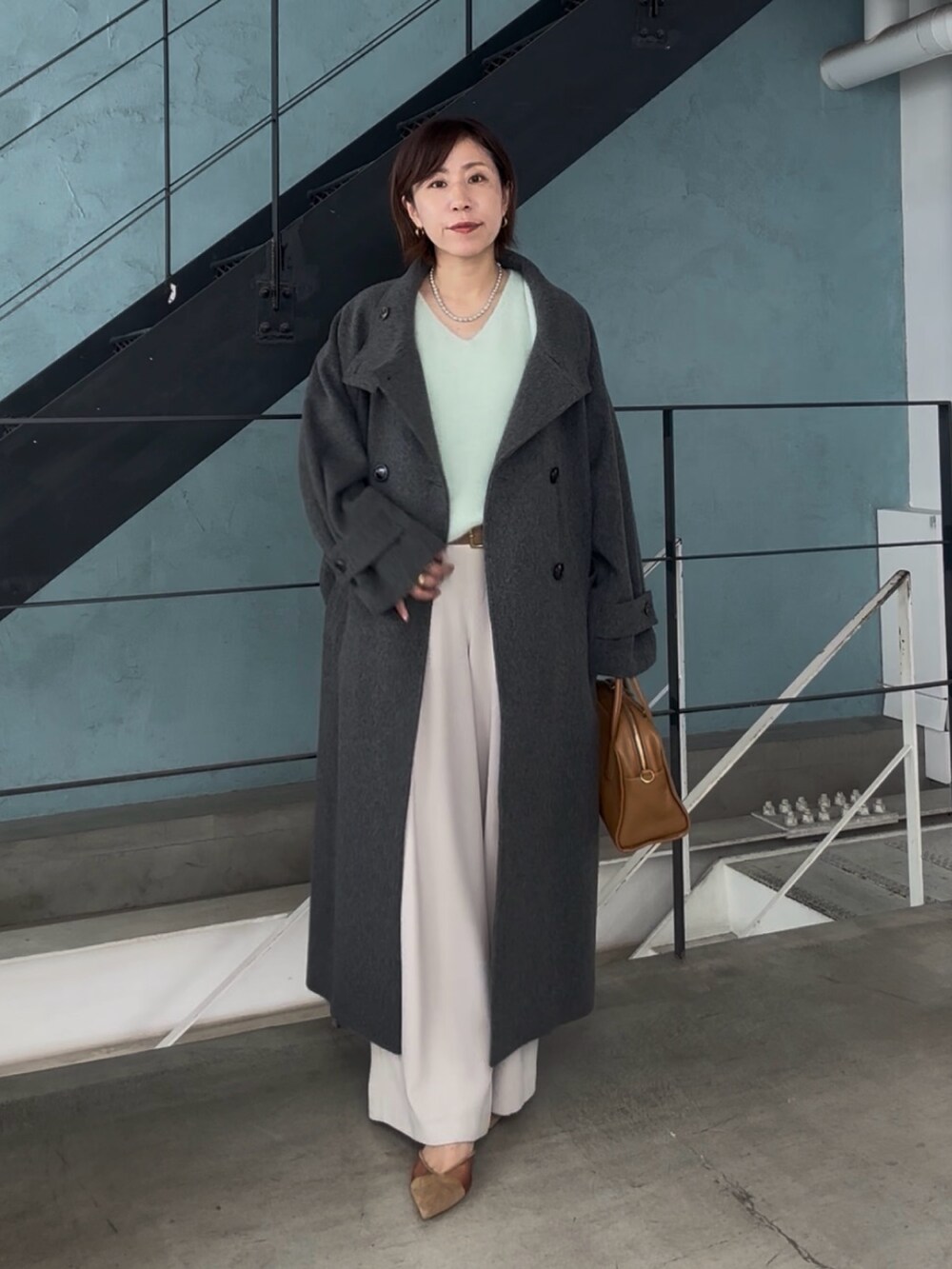 グレー系のその他アウター、グレー系のスラックス、ブラウン系のパンプスを着用したレディースの秋コーディネートの2枚目の写真