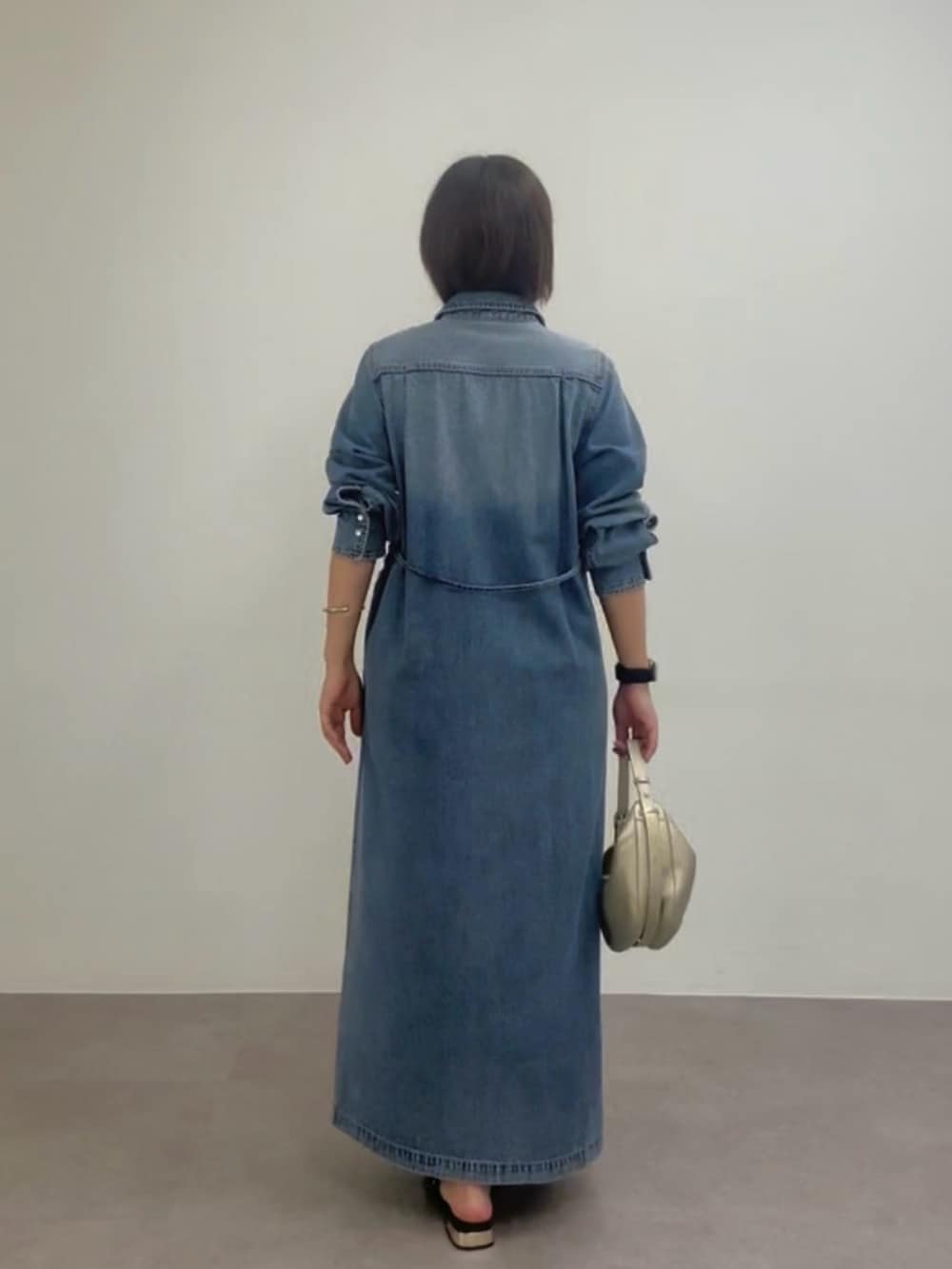 ブルー系のワンピース、ゴールド系のショルダーバッグ、ベージュ系のその他シューズを着用したレディースの春コーディネートの4枚目の写真