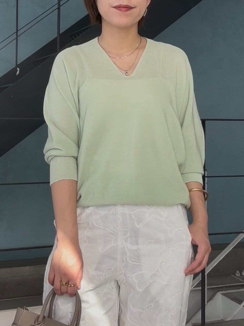 グリーン系のニット/セーター、グレー系のトートバッグ、シルバー系のその他シューズを着用したレディースの冬コーディネートの6枚目の写真