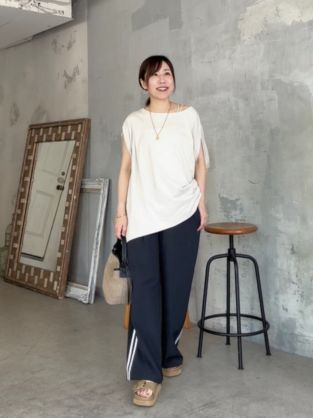 ベージュ系のTシャツ/カットソー、ブルー系のその他パンツ、ベージュ系のサンダルを着用したレディースの夏コーディネートの2枚目の写真