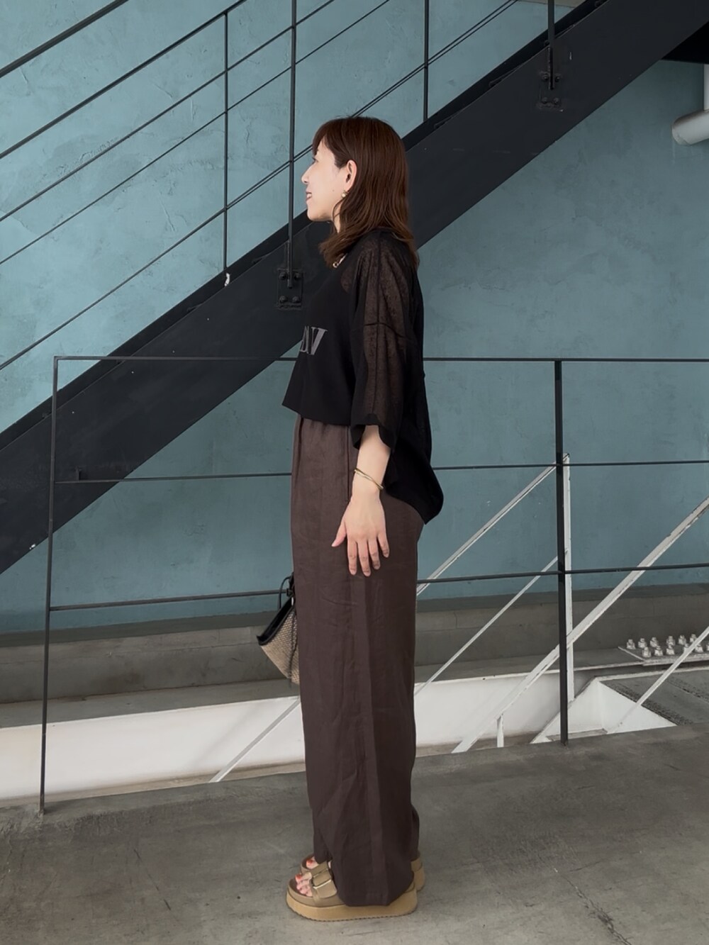 ブラック系のニット/セーター、ブラック系のその他パンツ、ベージュ系のサンダルを着用したレディースの春コーディネートの4枚目の写真