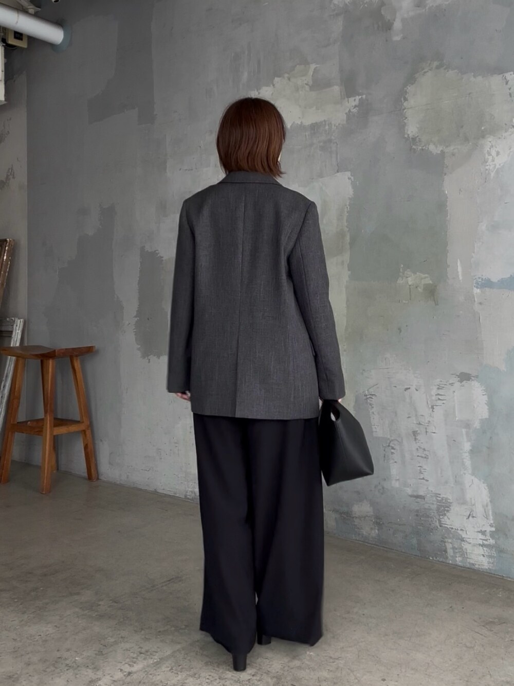 ブラック系のスラックス、ホワイト系のTシャツ/カットソー、グレー系のテーラードジャケットを着用したレディースの秋コーディネートの5枚目の写真