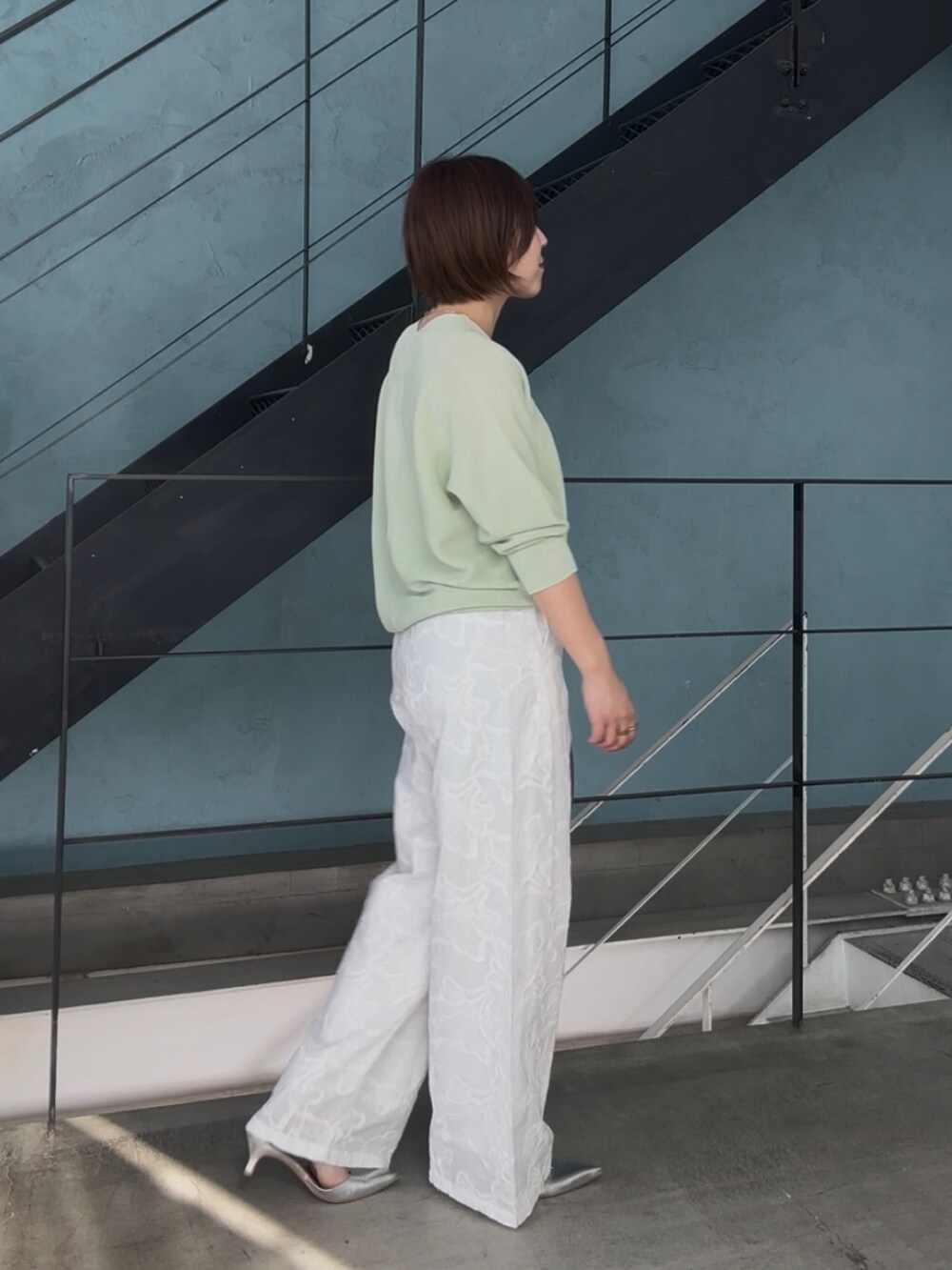 グリーン系のニット/セーター、グレー系のトートバッグ、シルバー系のその他シューズを着用したレディースの冬コーディネートの4枚目の写真