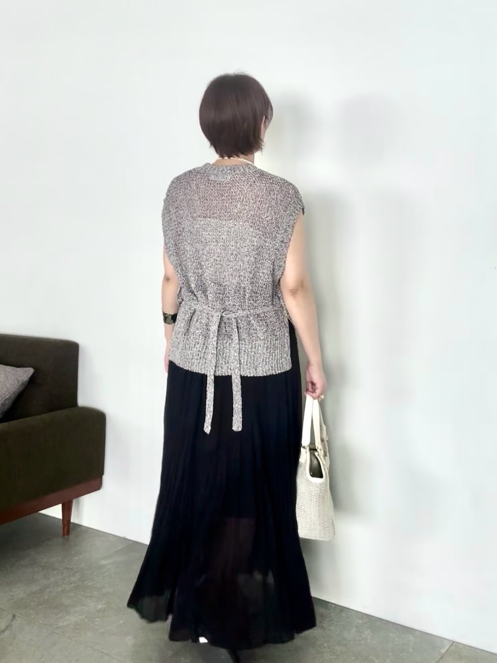 ブラック系のニット/セーター、ブラック系のスカート、ブラック系のサンダルを着用したレディースの夏コーディネートの5枚目の写真