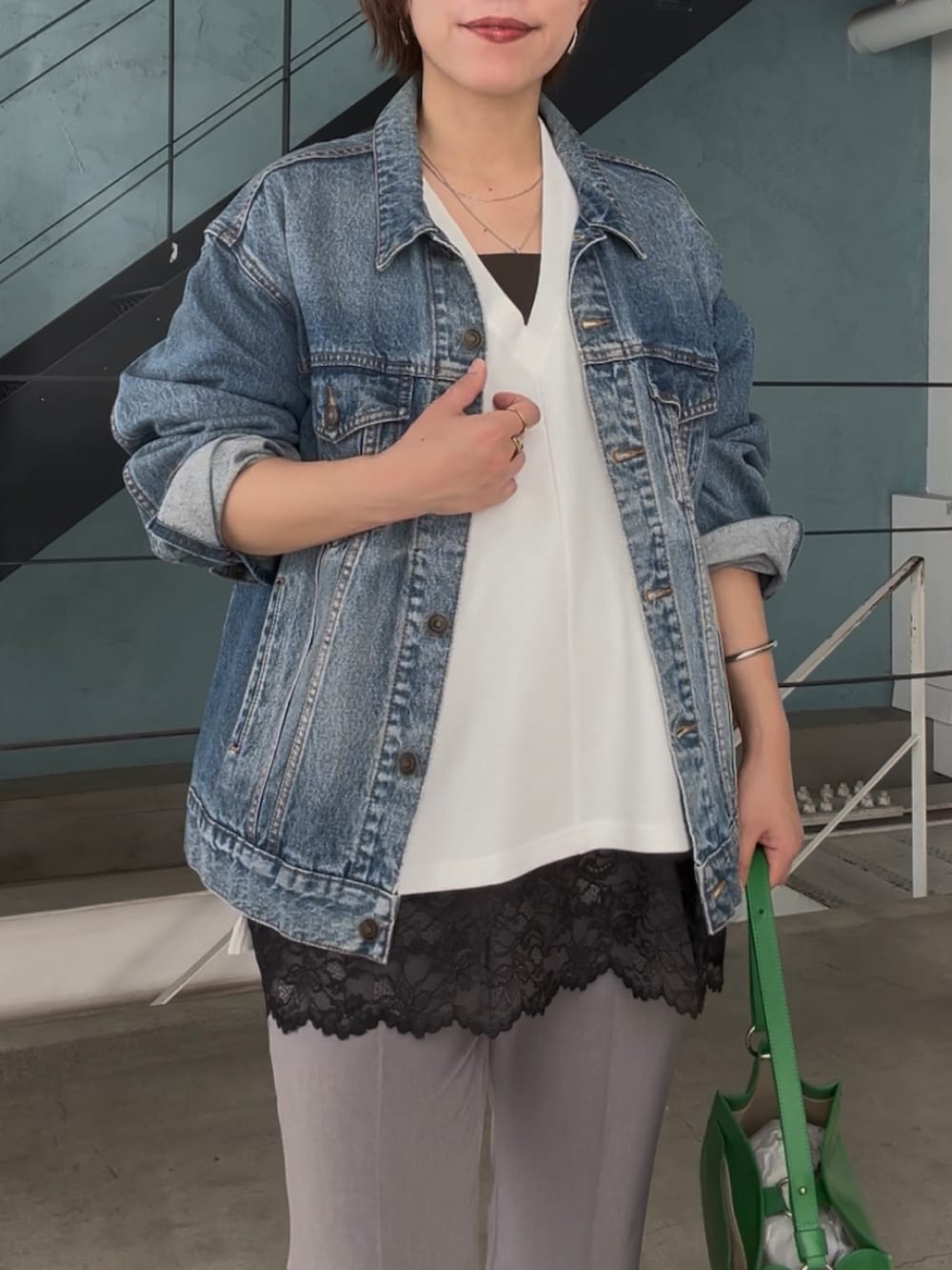 ブルー系のデニムジャケット、ホワイト系のスウェット、ブラック系のキャミソールを着用したレディースの冬コーディネートの6枚目の写真