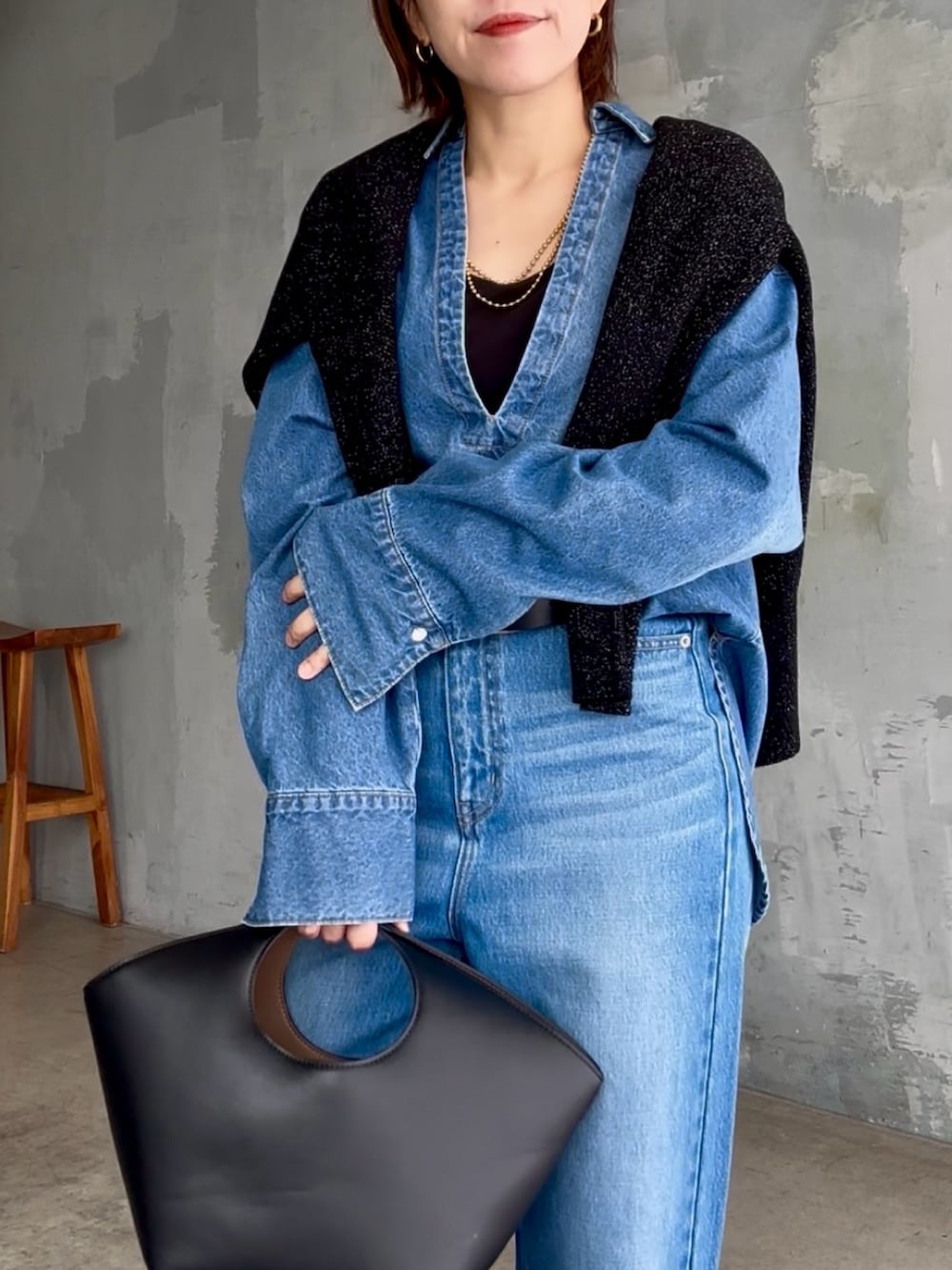ブラック系のハンドバッグ、ブルー系のデニムパンツ、ブルー系のシャツ/ブラウスを着用したレディースの秋コーディネートの5枚目の写真