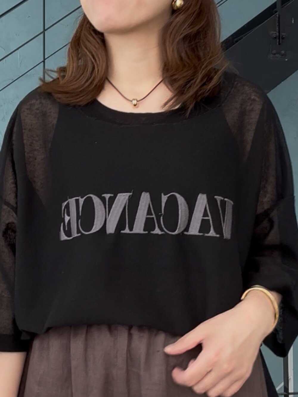 ブラック系のニット/セーター、ブラック系のその他パンツ、ベージュ系のサンダルを着用したレディースの春コーディネートの6枚目の写真