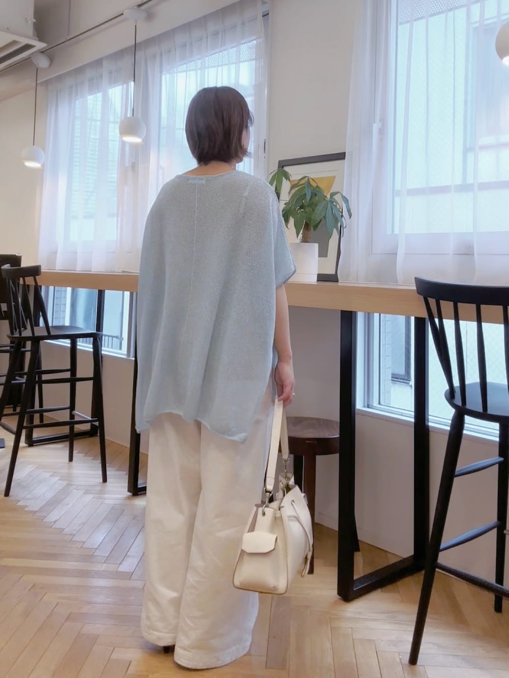 ホワイト系のデニムパンツ、ホワイト系のショルダーバッグ、ブルー系のニット/セーターを着用したレディースの春コーディネートの5枚目の写真