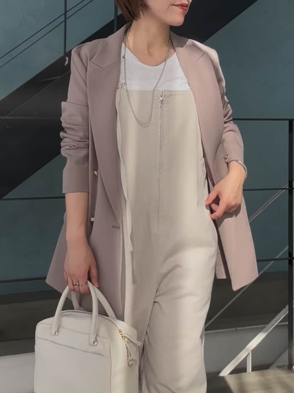 シルバー系のその他シューズ、ホワイト系のボストンバッグ、ベージュ系のサロペット/オーバーオールを着用したレディースの冬コーディネートの7枚目の写真