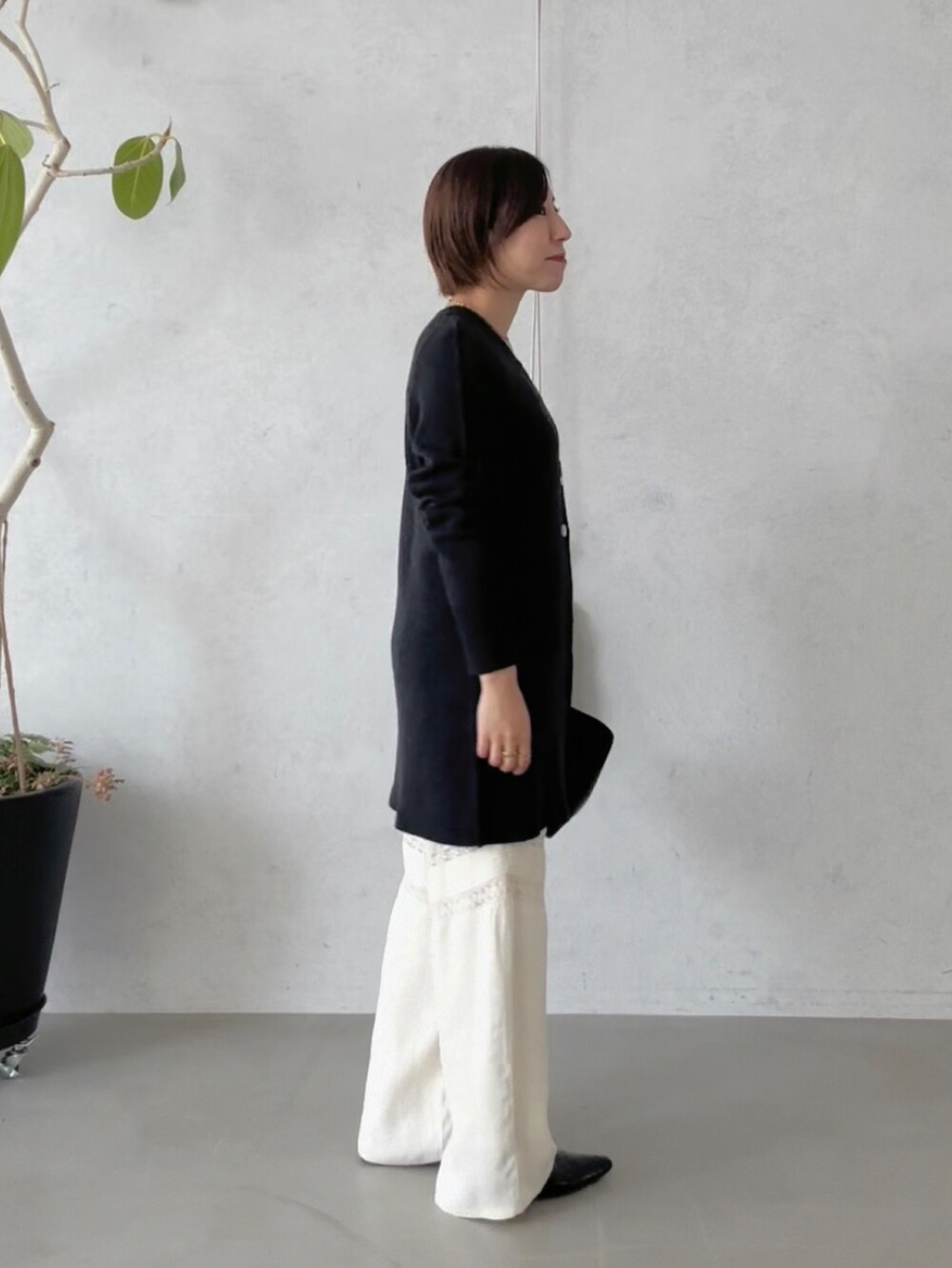 ホワイト系のその他パンツ、ブラック系のハンドバッグ、ブラック系のその他シューズを着用したレディースの冬コーディネートの3枚目の写真