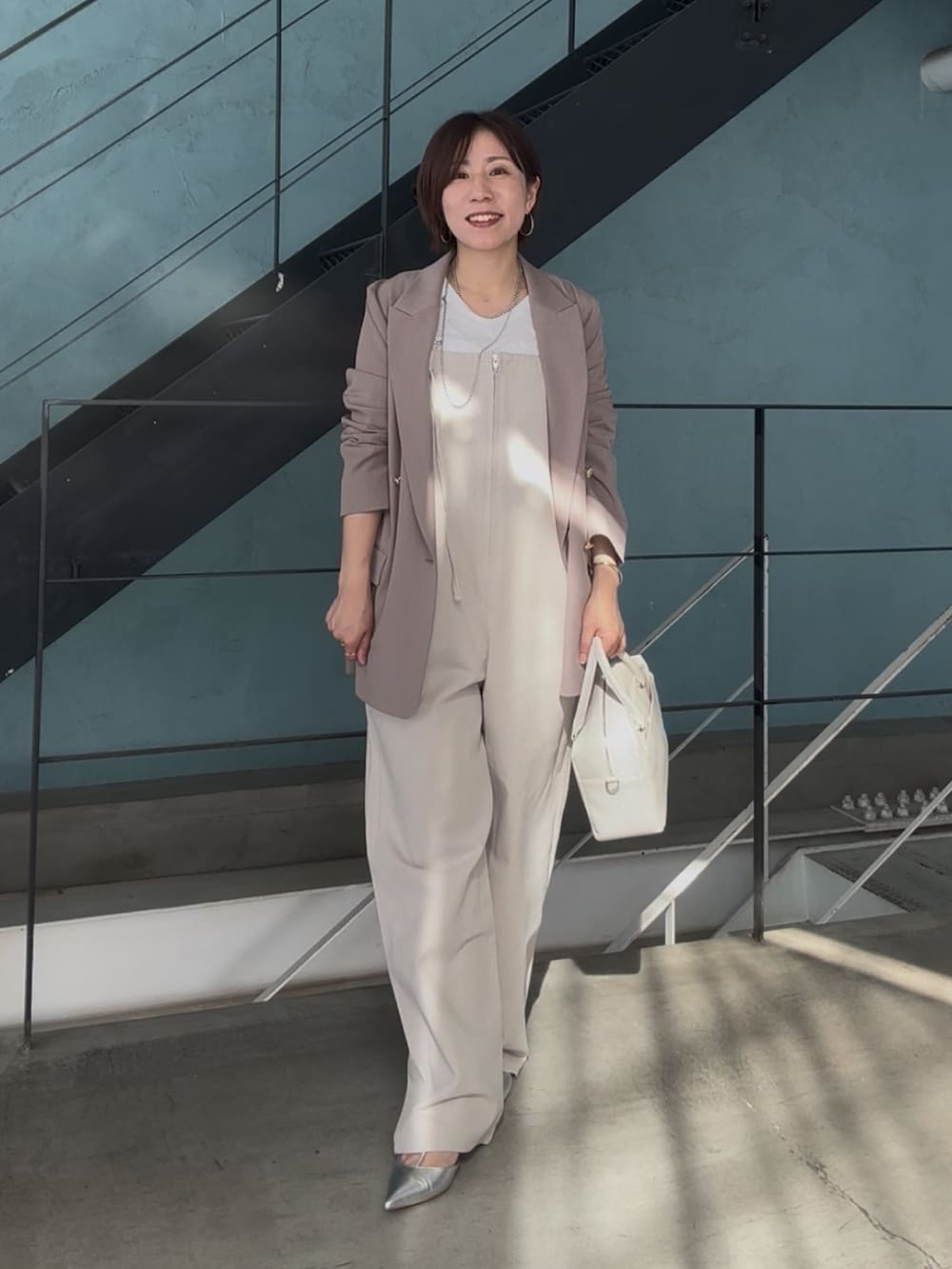 シルバー系のその他シューズ、ホワイト系のボストンバッグ、ベージュ系のサロペット/オーバーオールを着用したレディースの冬コーディネートの3枚目の写真