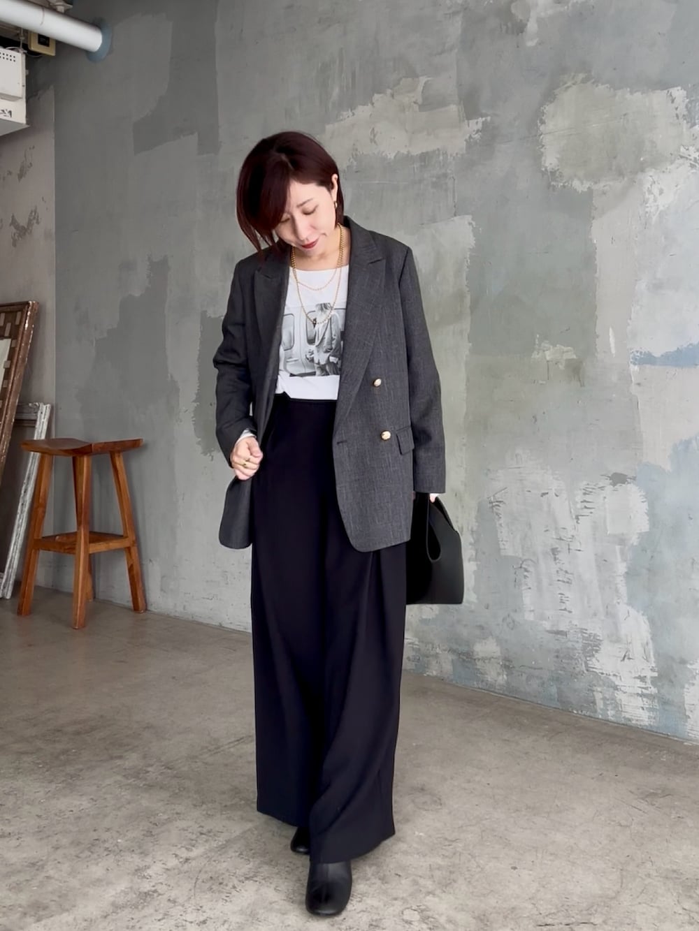 ブラック系のスラックス、ホワイト系のTシャツ/カットソー、グレー系のテーラードジャケットを着用したレディースの秋コーディネートの3枚目の写真