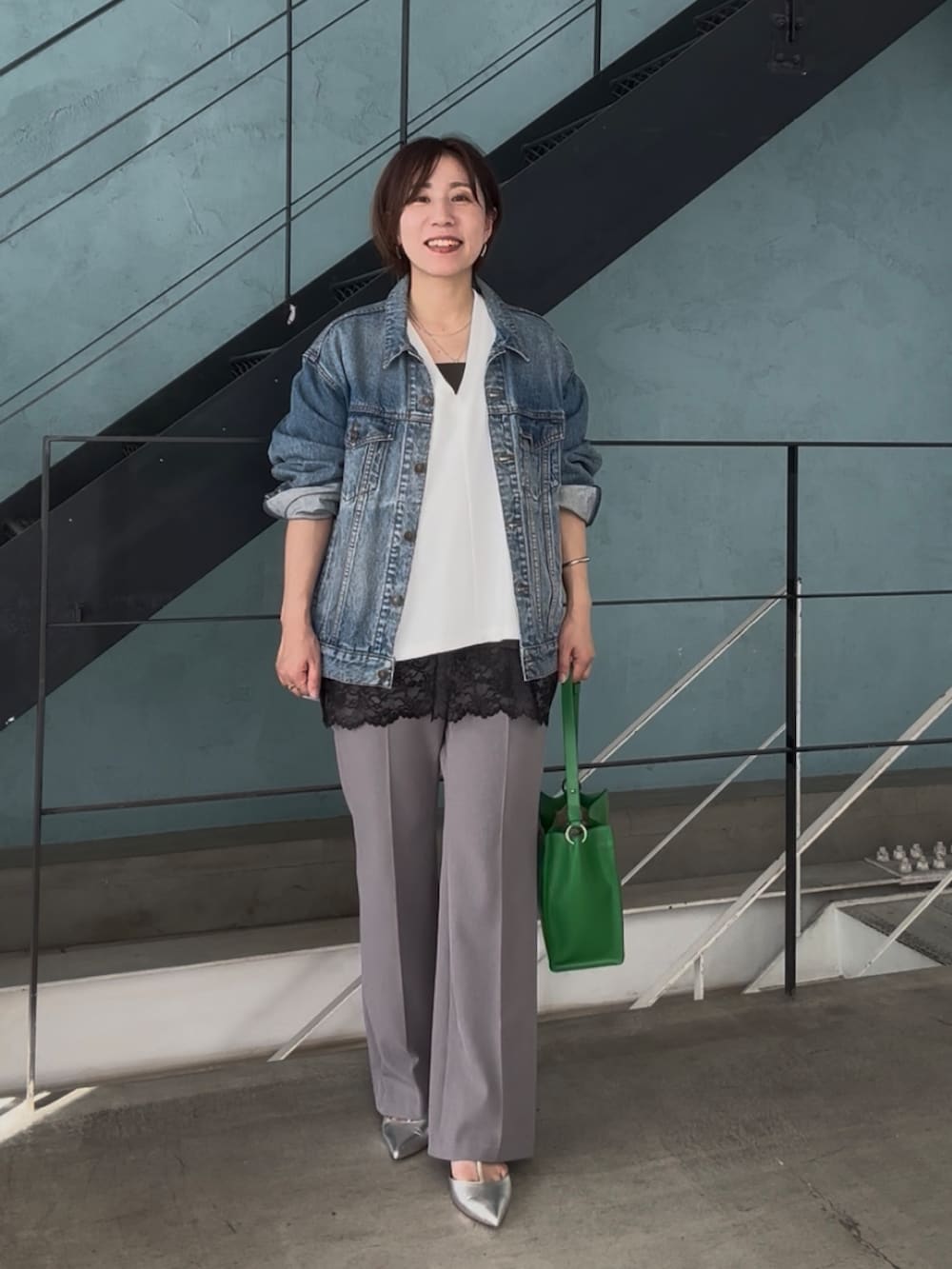 ブルー系のデニムジャケット、ホワイト系のスウェット、ブラック系のキャミソールを着用したレディースの冬コーディネートの3枚目の写真