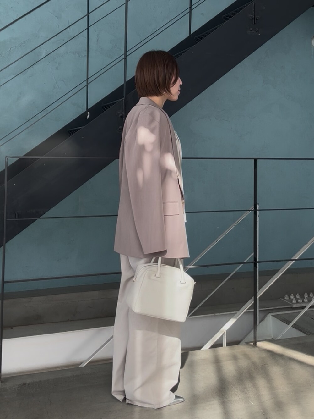 シルバー系のその他シューズ、ホワイト系のボストンバッグ、ベージュ系のサロペット/オーバーオールを着用したレディースの冬コーディネートの5枚目の写真