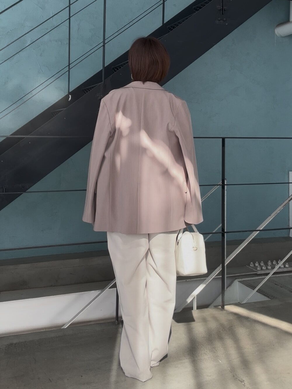 シルバー系のその他シューズ、ホワイト系のボストンバッグ、ベージュ系のサロペット/オーバーオールを着用したレディースの冬コーディネートの6枚目の写真