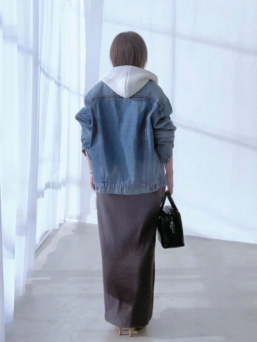 ブルー系のデニムジャケット、グレー系のワンピース、ブラウン系のパンプスを着用したレディースの冬コーディネートの5枚目の写真