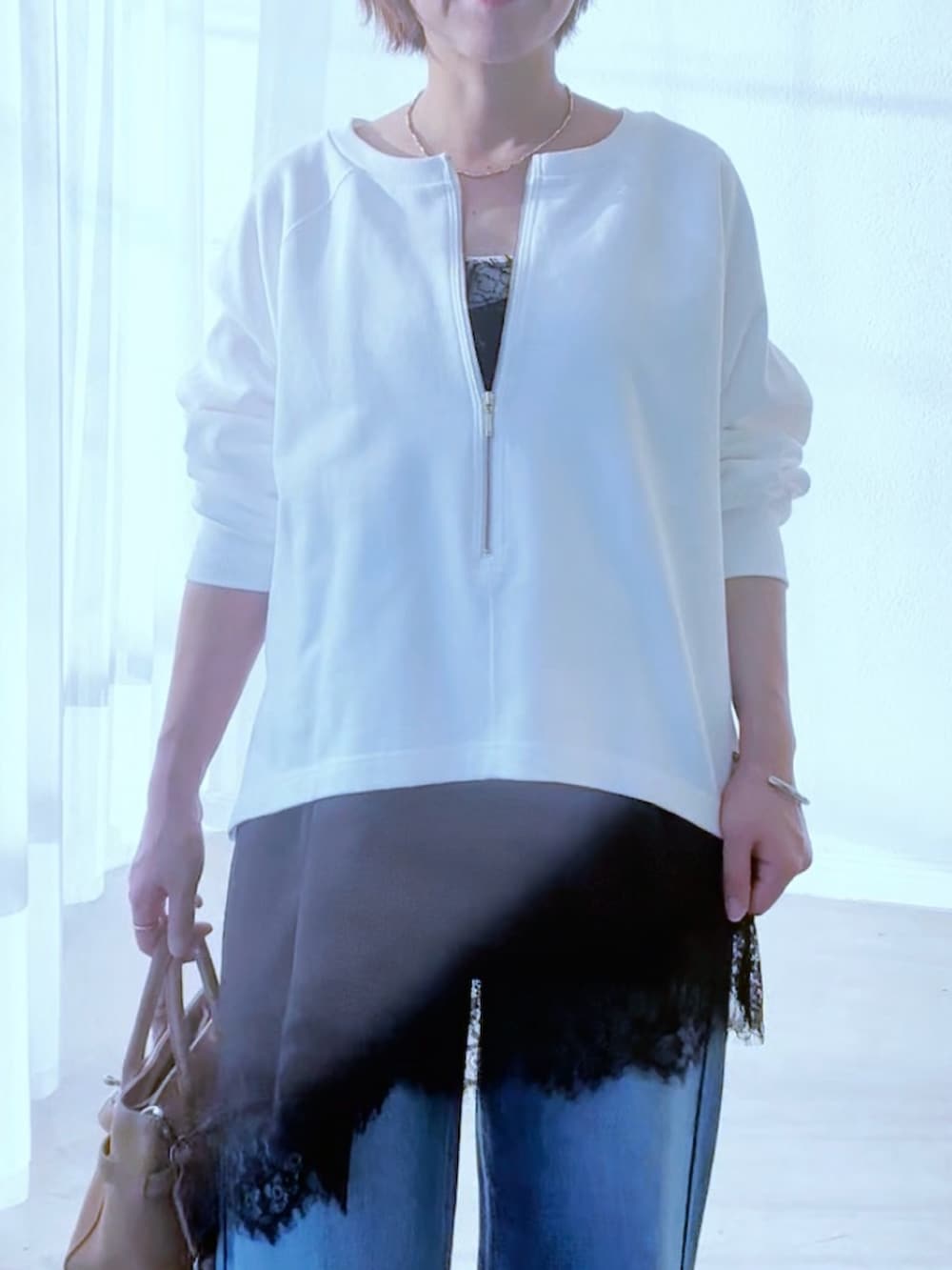 ホワイト系のスウェット、ブラック系のキャミソール、ブルー系のデニムパンツを着用したレディースの冬コーディネートの6枚目の写真