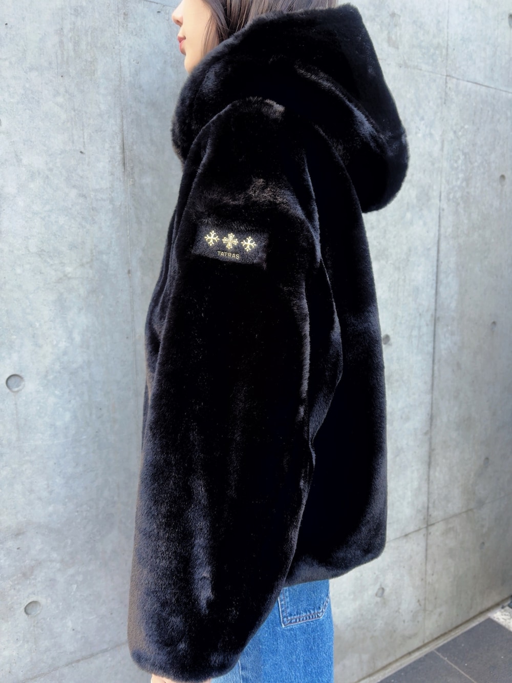 ブラック系のブーツ、ブルー系のデニムパンツ、ブラック系のブルゾンを着用したレディースの秋コーディネートの3枚目の写真