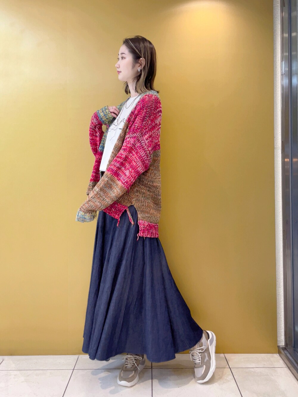 ホワイト系のTシャツ/カットソー、ブルー系のスカート、ベージュ系のスニーカーを着用したレディースの夏コーディネートの2枚目の写真