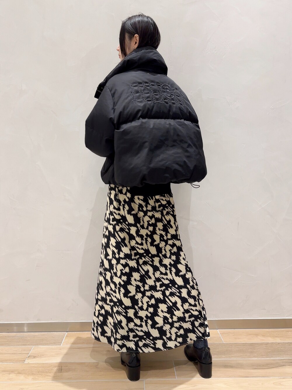 ブラック系のスカートを着用したレディースの秋コーディネートの2枚目の写真