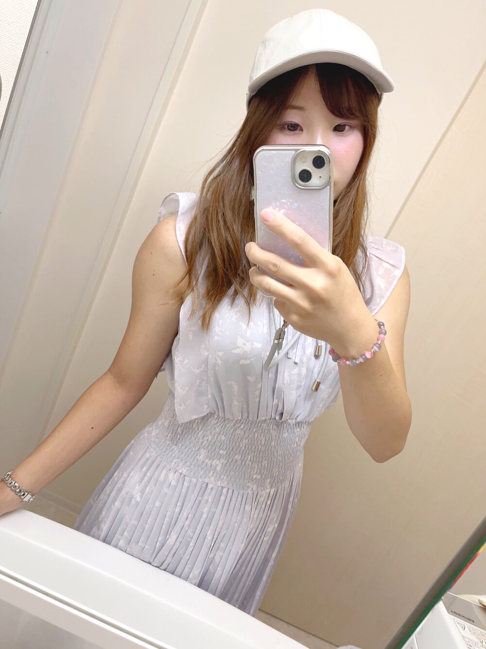 パープル系のワンピース、グレー系のキャップを着用したレディースの夏コーディネートの2枚目の写真