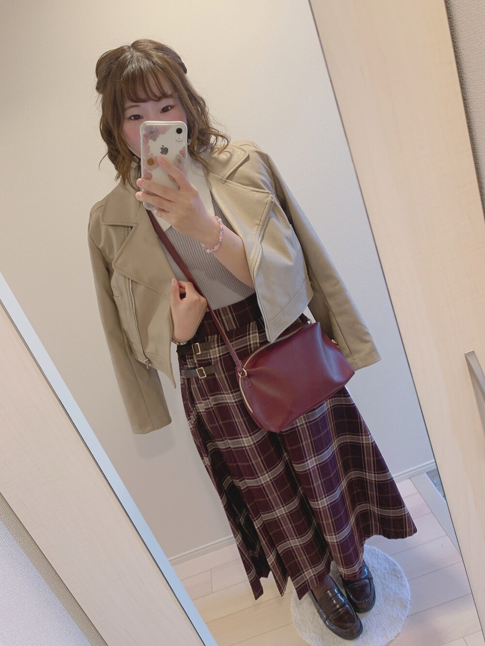 グレー系のニット/セーター、レッド系のスカート、ブラウン系のローファーを着用したレディースの秋コーディネートの2枚目の写真