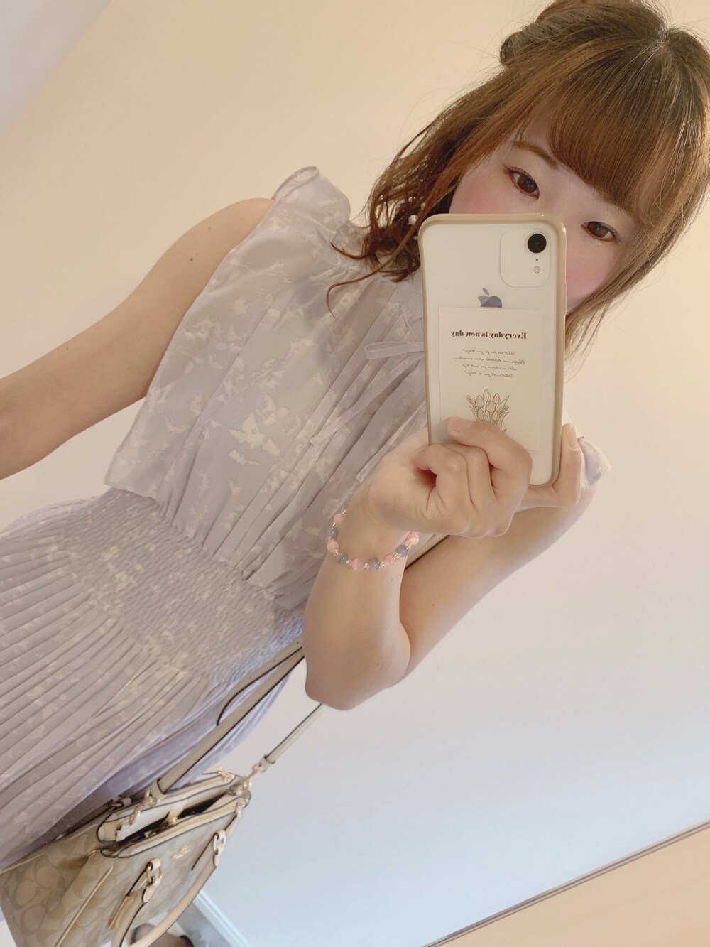 パープル系のワンピース、グレー系のサンダル、ベージュ系のバッグを着用したレディースの夏コーディネートの2枚目の写真