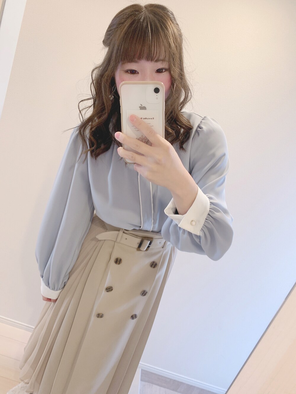 ブルー系のシャツ/ブラウス、ベージュ系のスカート、ブラウン系のローファーを着用したレディースの春コーディネートの2枚目の写真