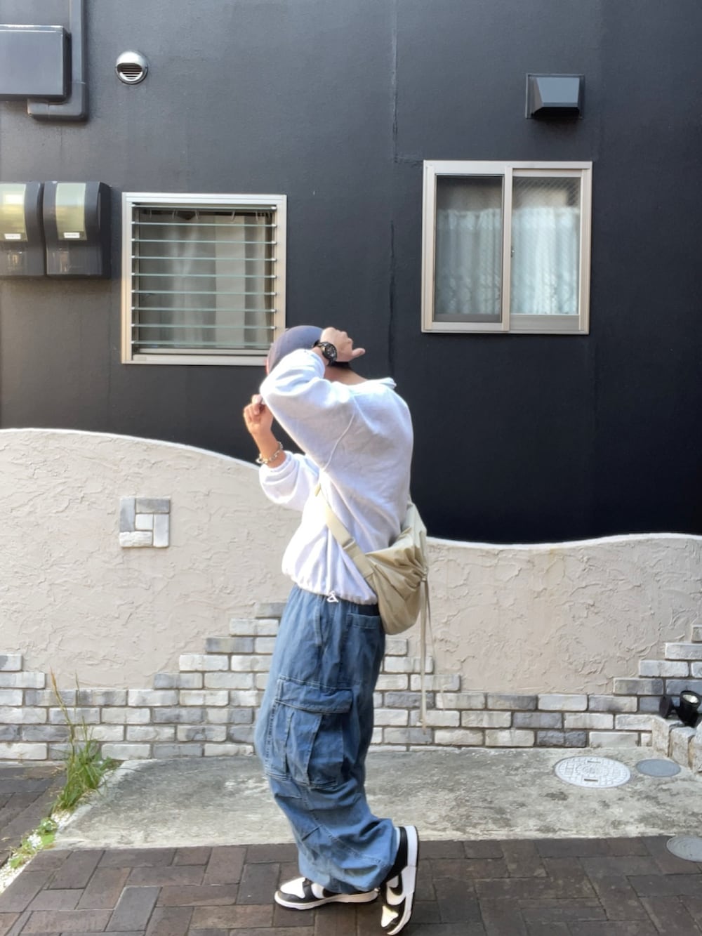 ブルー系のカーゴパンツ、ホワイト系のスニーカー、ホワイト系のスウェットを着用したメンズの秋コーディネートの2枚目の写真