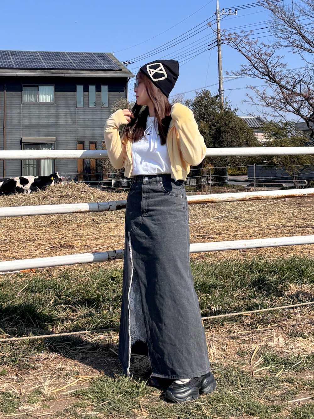ブラック系のスニーカー、ホワイト系のTシャツ/カットソー、イエロー系のジャケット/アウターを着用したレディースの冬コーディネートの2枚目の写真