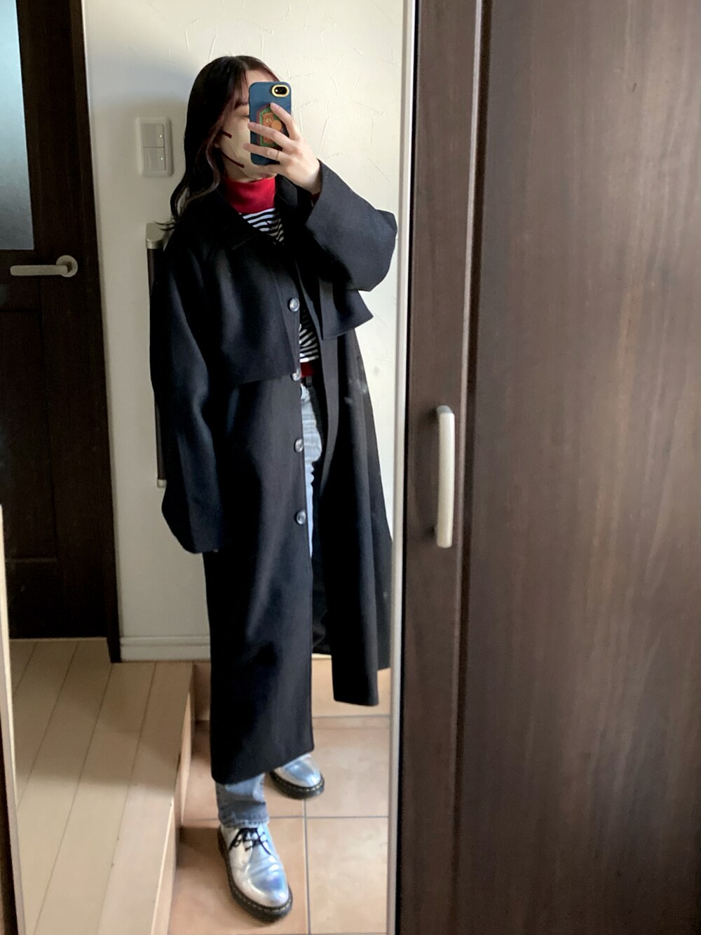 ホワイト系のバッグ、シルバー系のシューズ、ブラック系のデニムパンツを着用したレディースの冬コーディネートの2枚目の写真