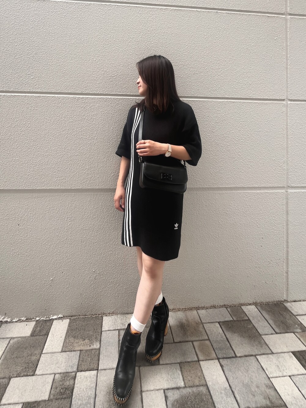 ブラック系のブーツ、ブラック系のショルダーバッグ、ブラック系のワンピース/ドレスを着用したレディースの夏コーディネートの2枚目の写真