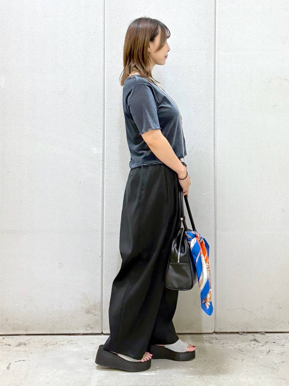 シルバー系のサンダル、ブラック系のその他パンツ、ブラック系のボストンバッグを着用したレディースの夏コーディネートの7枚目の写真