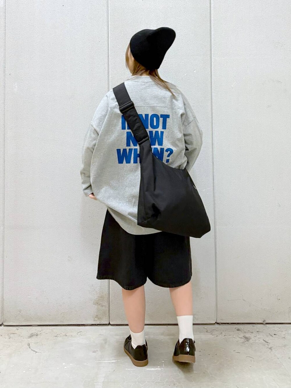 グレー系のワンピース、ブラック系のショルダーバッグ、ブラック系のスニーカーを着用したレディースの春コーディネートの4枚目の写真