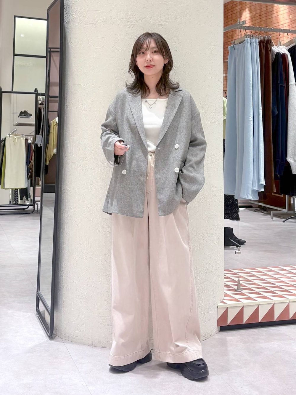 グレー系のテーラードジャケット、ピンク系のデニムパンツ、ブラック系のローファーを着用したレディースの冬コーディネートの2枚目の写真