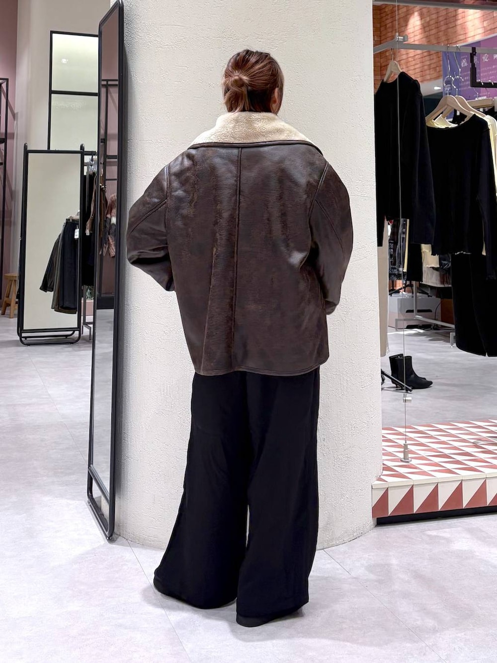 ブラウン系のムートンコート、ブラック系のその他パンツ、ブラック系のブーツを着用したレディースの冬コーディネートの4枚目の写真