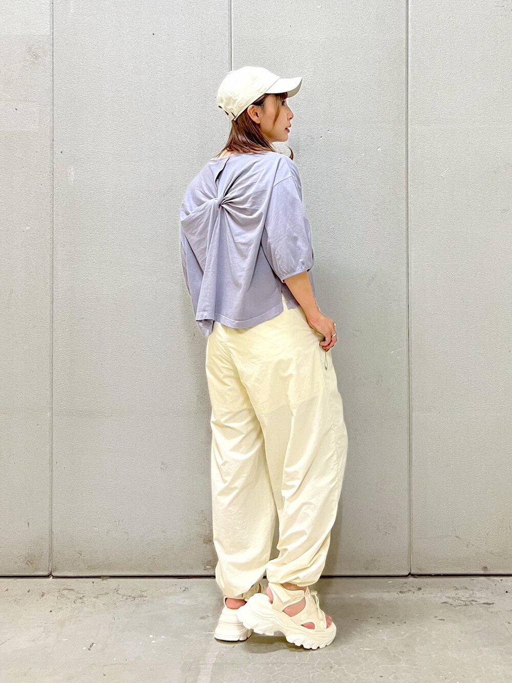 ホワイト系のサンダル、ホワイト系のカーゴパンツ、パープル系のTシャツ/カットソーを着用したレディースの夏コーディネートの2枚目の写真