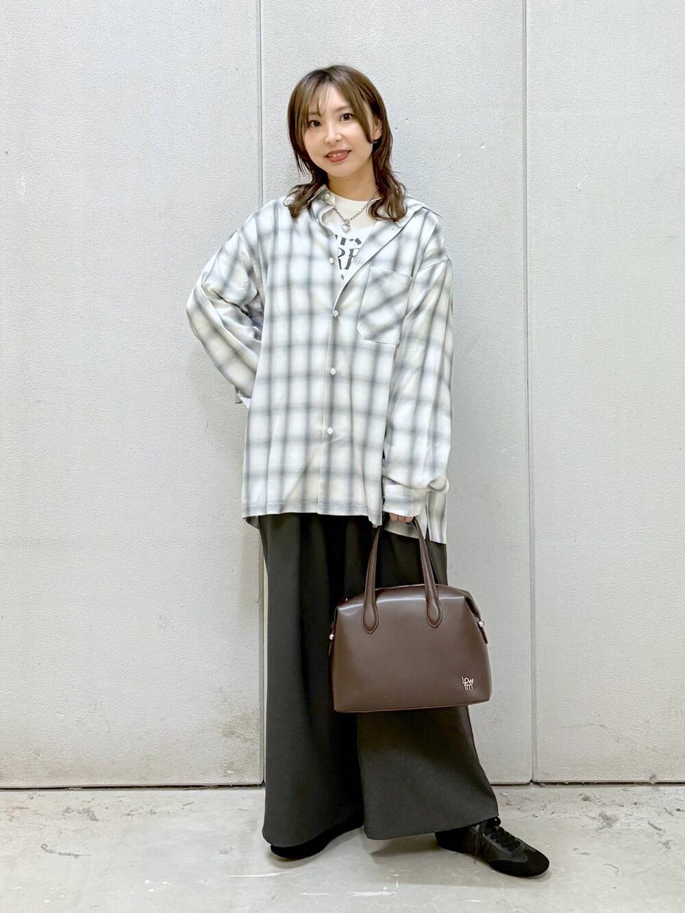 ホワイト系のTシャツ/カットソー、ブラウン系のショルダーバッグ、ブラック系のスニーカーを着用したレディースの冬コーディネートの6枚目の写真