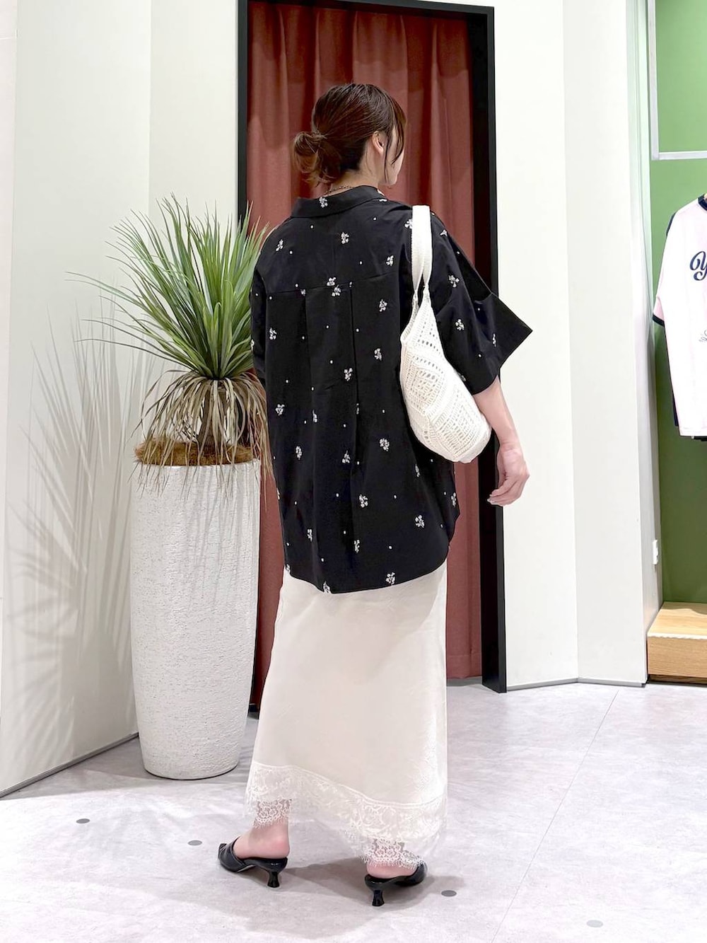 ホワイト系のスカート、ホワイト系のトートバッグ、ブラック系のシャツ/ブラウスを着用したレディースの夏コーディネートの4枚目の写真