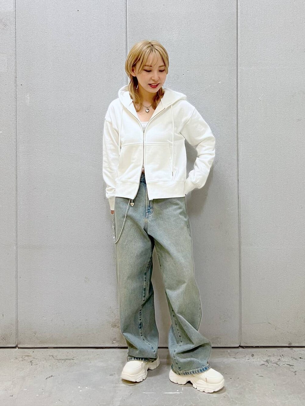 ブルー系のデニムパンツ、ホワイト系のスニーカー、ホワイト系のTシャツ/カットソーを着用したレディースの秋コーディネートの2枚目の写真