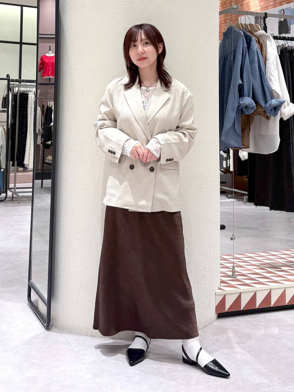ブラウン系のスカート、ベージュ系のその他アウター、ブラック系のサンダルを着用したレディースの春コーディネートの4枚目の写真