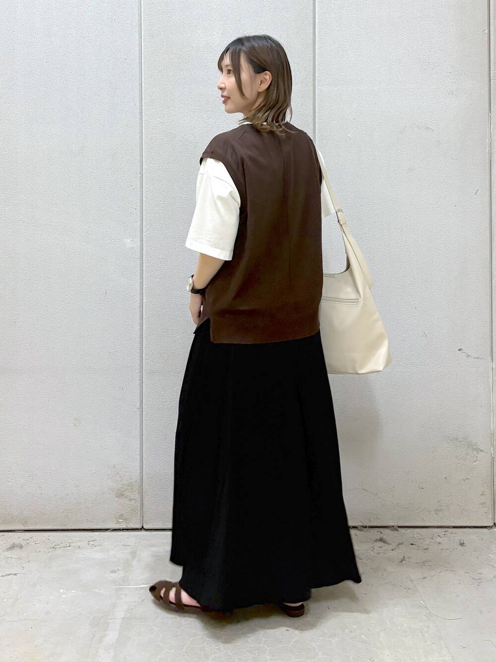 ホワイト系のショルダーバッグ、ホワイト系のTシャツ/カットソー、ブラウン系のサンダルを着用したレディースの夏コーディネートの3枚目の写真