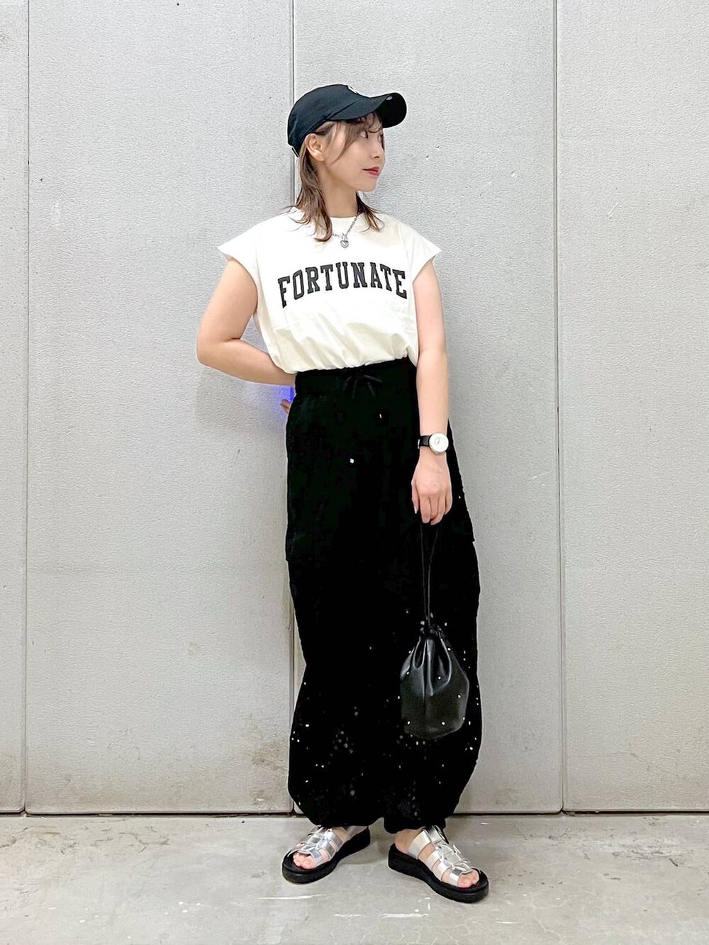 ブラック系のハンドバッグ、シルバー系のスニーカー、ブラック系のカーゴパンツを着用したレディースの春コーディネートの4枚目の写真